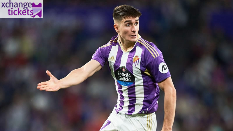 Spanish defender Iván Fresneda gesturing on the pitch in a purple and white striped jersey.